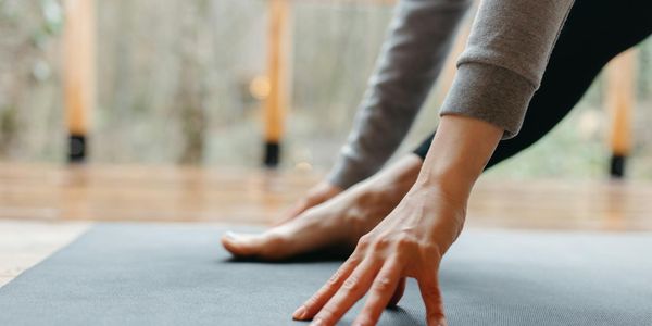 Close up of hands on a yoga mat during a stretch