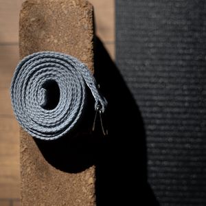 Minimalist yoga equipment on a dark floor